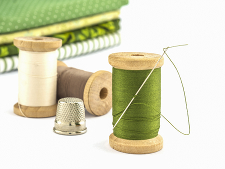 Wooden spool of thread embroidery set with cloth over white backgroundの写真素材