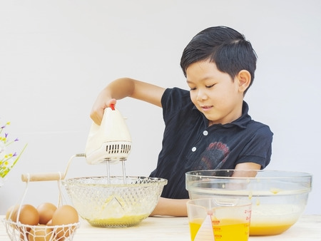 A boy is making cake.の写真素材