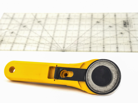 Rotary for embroidery work with plastic ruler plate over white background