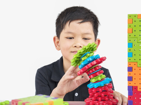 Asian children are playing puzzle plastic block creative game to practice their physical and mental skillの写真素材