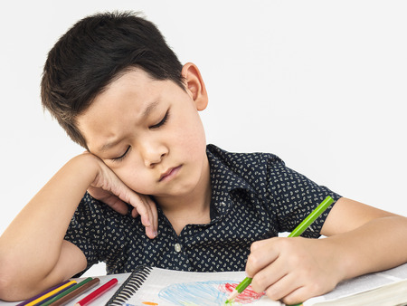 A boy is unhappy doing homeworkの写真素材