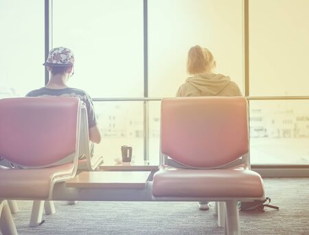 Passengers are sitting wait for their flight at airport, vintage style photo.の写真素材
