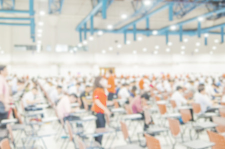 Blurred photo of crowded people taking examination in a big hallの写真素材