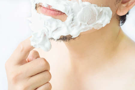 Man is smearing foam to his face prepare for shaving