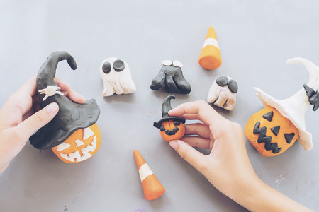 Girl is playing Halloween clay toy of jack o lantern pumpkin facesの写真素材