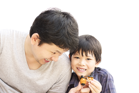 Father is playing Halloween clay with his son over white backgroundの写真素材