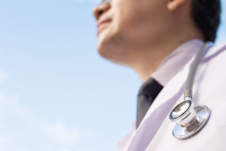 Male doctor is looking at the blue sky. Concept for good future of medical service.の写真素材