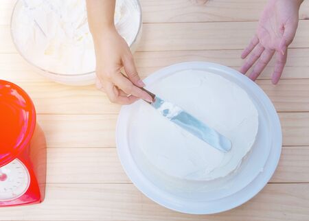Putting butter  cream cake by hand using spatulaの写真素材