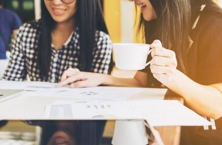 Working women are discussing in their officeの写真素材