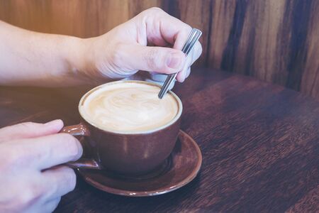 Selective focus of man stirring coffeeの写真素材