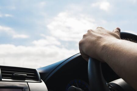 Man driving car using one handの写真素材