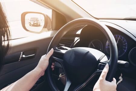 Woman driving car using two handの写真素材