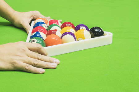 Man setting pool ball for snooker table before starting new game