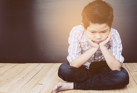 7 years old Asian boy is feeling sadの写真素材