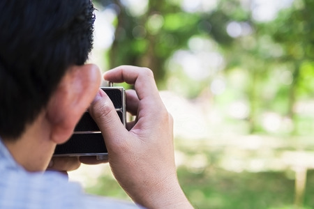 Man taking photo using old retro cameraの写真素材