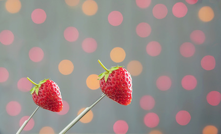 Fresh Strawberries over colorful light bokeh backgroundの写真素材