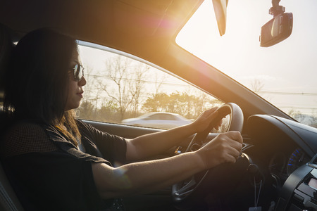 Woman driving car using two handの写真素材
