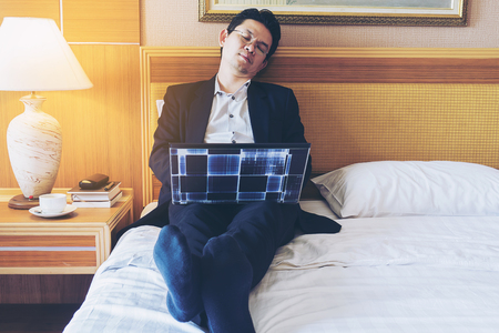 Business man take a nap while working in hotel roomの写真素材