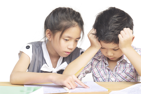 Sister try to teach her naughty younger brother to do homework  isolated over white backgroundの写真素材