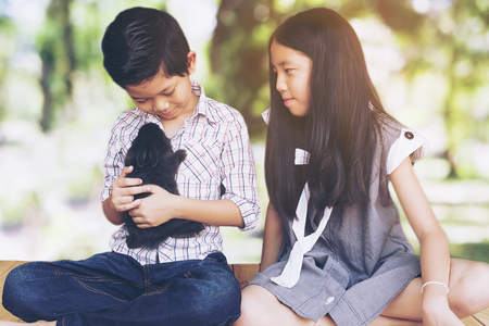 Boy and girl playing with baby rabbitの写真素材