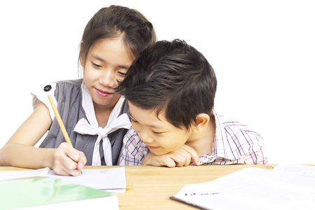 Kid are doing homework together over white backgroundの写真素材