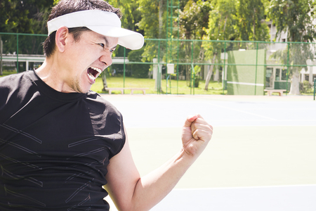 Tennis player aggressively expresses his victoryの写真素材
