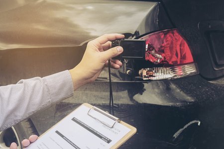 Insurance agent working on car accident claim processの写真素材