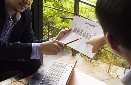 Two businessman discussing their chart in coffee shopの写真素材