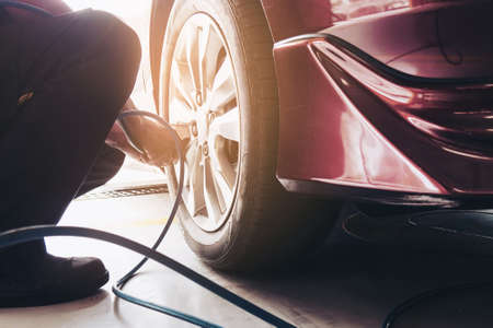 Technician is inflate car tire - car maintenance service transportation safety concept