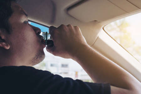 Man taking health drink while driving care for awake refreshment and robust drive - drive safe with some refreshment drink conceptの写真素材