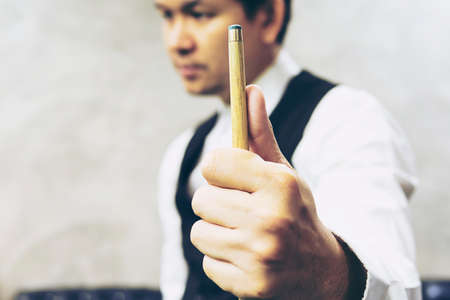 Snooker player standing hold his cue stick prepare for his turn during competition matchの写真素材