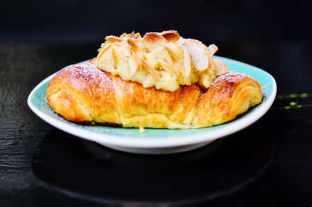 Fresh croissant with almonds on the plate