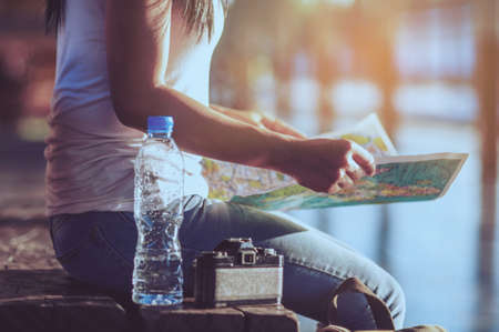 Tourist travel woman looking at the map while walking on a street  - street backpack travel concept