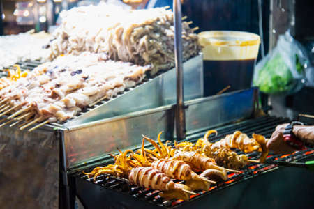 Grilled squid seller in local street food in Yaowarat road famous tourist place Thailandの写真素材