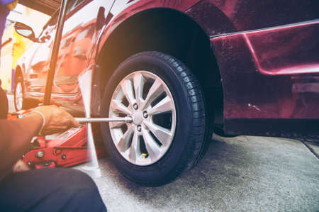 Worker putting new wheel to the carの写真素材