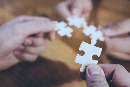 One white jigsaw being focused and another three being blur at the backの写真素材