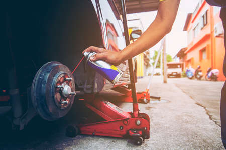 Worker going to put new wheel to the carの写真素材