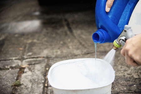 Man prepare shampoo water for washing car using - home people car clean conceptの写真素材