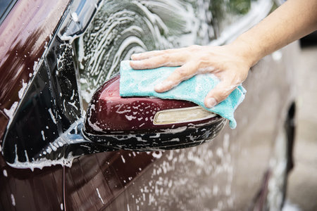 Man wash car using shampoo - every day life car care conceptの写真素材