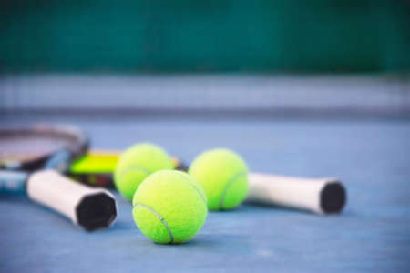 Tennis racket with ball on blue hard court with nobody - tennis sport background concept