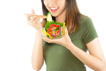 Happy lady enjoy eating vegetable salad over white copy space background - people with organic healthy food conceptの写真素材