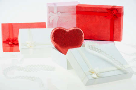 Red heart shape chocolate with small present boxes and ribbon decoration - love and presents decoration conceptの写真素材
