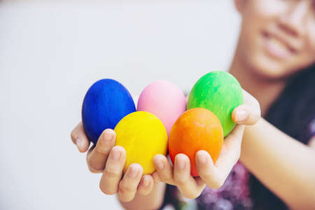 Child showing colorful Easter eggs happily - Easter holiday celebration concept