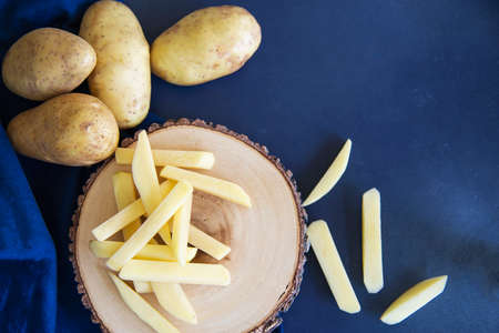 Sliced potato stick ready for making French fries - traditional food preparation conceptの写真素材