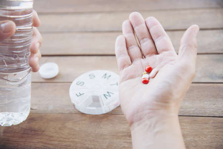 People prepare daily medicine tablet in pillbox - people healthcare with medicine pills concept