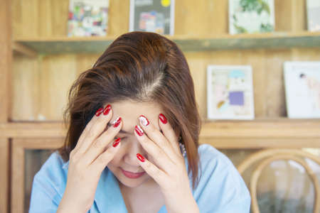 Sad depressed woman sitting in coffee shop - people with negative expression emotion concept