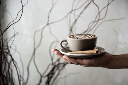 Hand holding hot coffee cup - people with coffee background concept