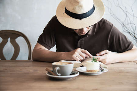 Relax Asian man drink coffee and read book in a modern style coffee shop - people with coffee cup easy lifestyle conceptの写真素材