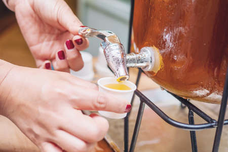 People taking sweet fruit juice from dispenser in morning breakfast time - people with beverage...