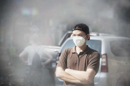 Man wearing mask protect fine dust in air pollution environment - people with protection equipment for air pollution conceptの写真素材